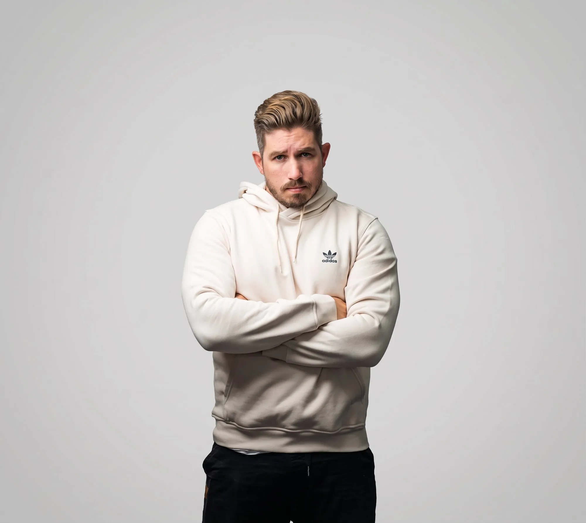 James Rhodes, arms crossed, in an adidas hoodie